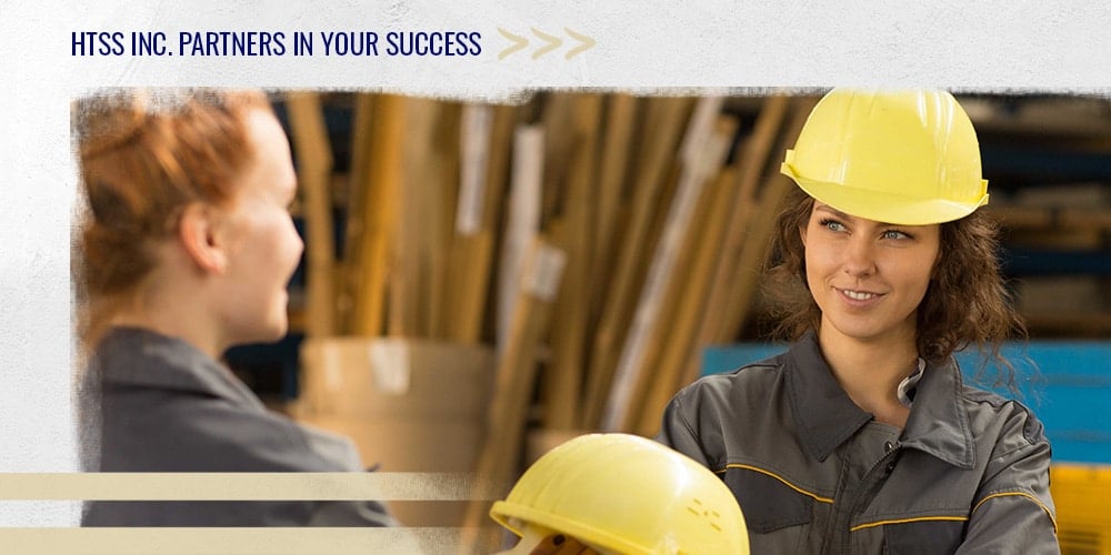 female worker handing hardhat to friend