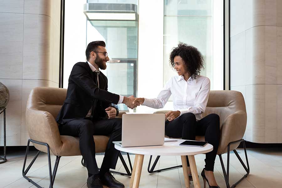 Diverse business partners shaking hands at meeting